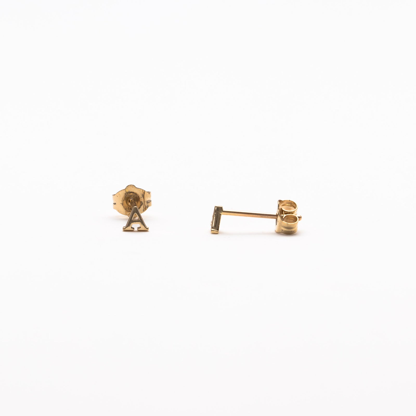 Single initial studs in yellow gold
