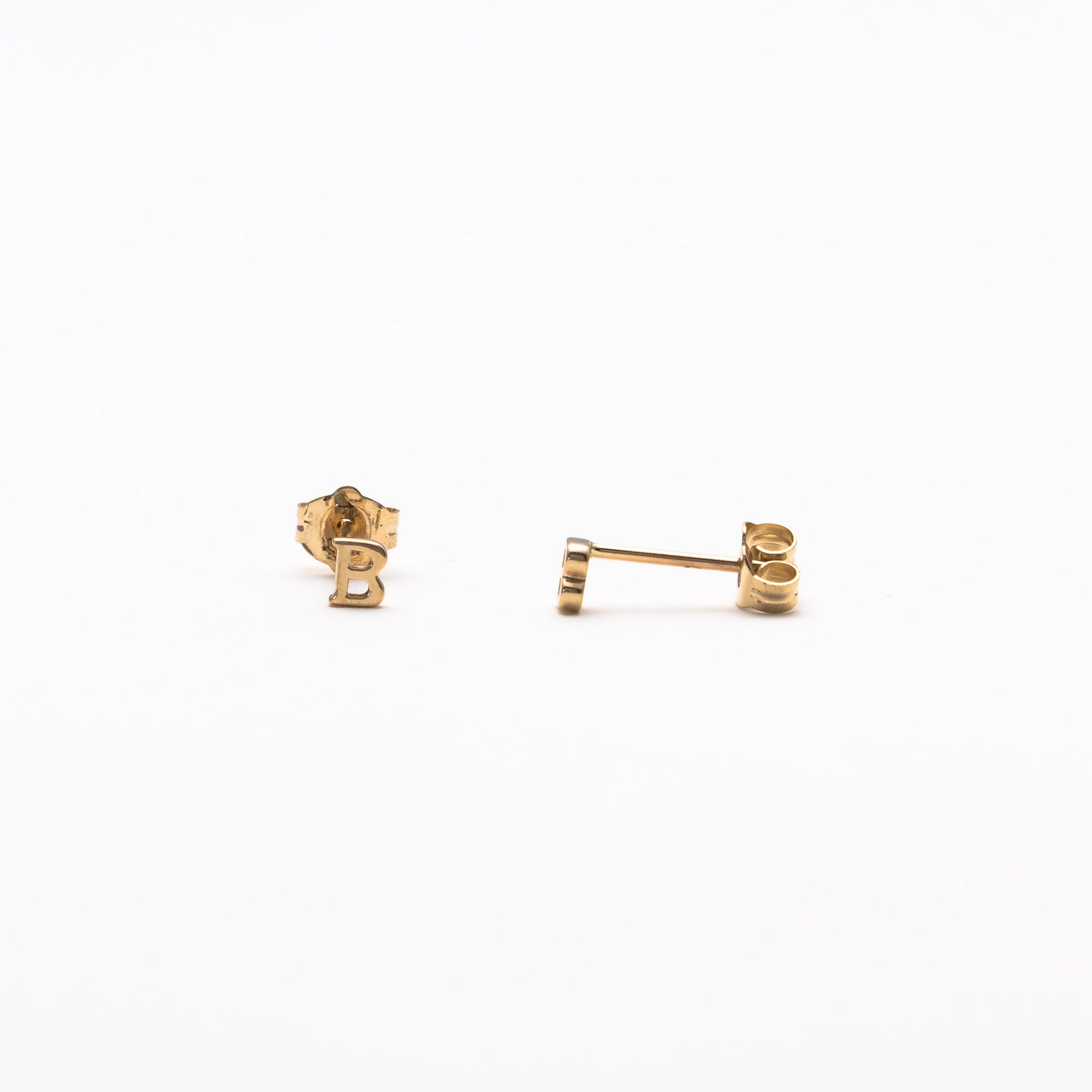 Single initial studs in yellow gold