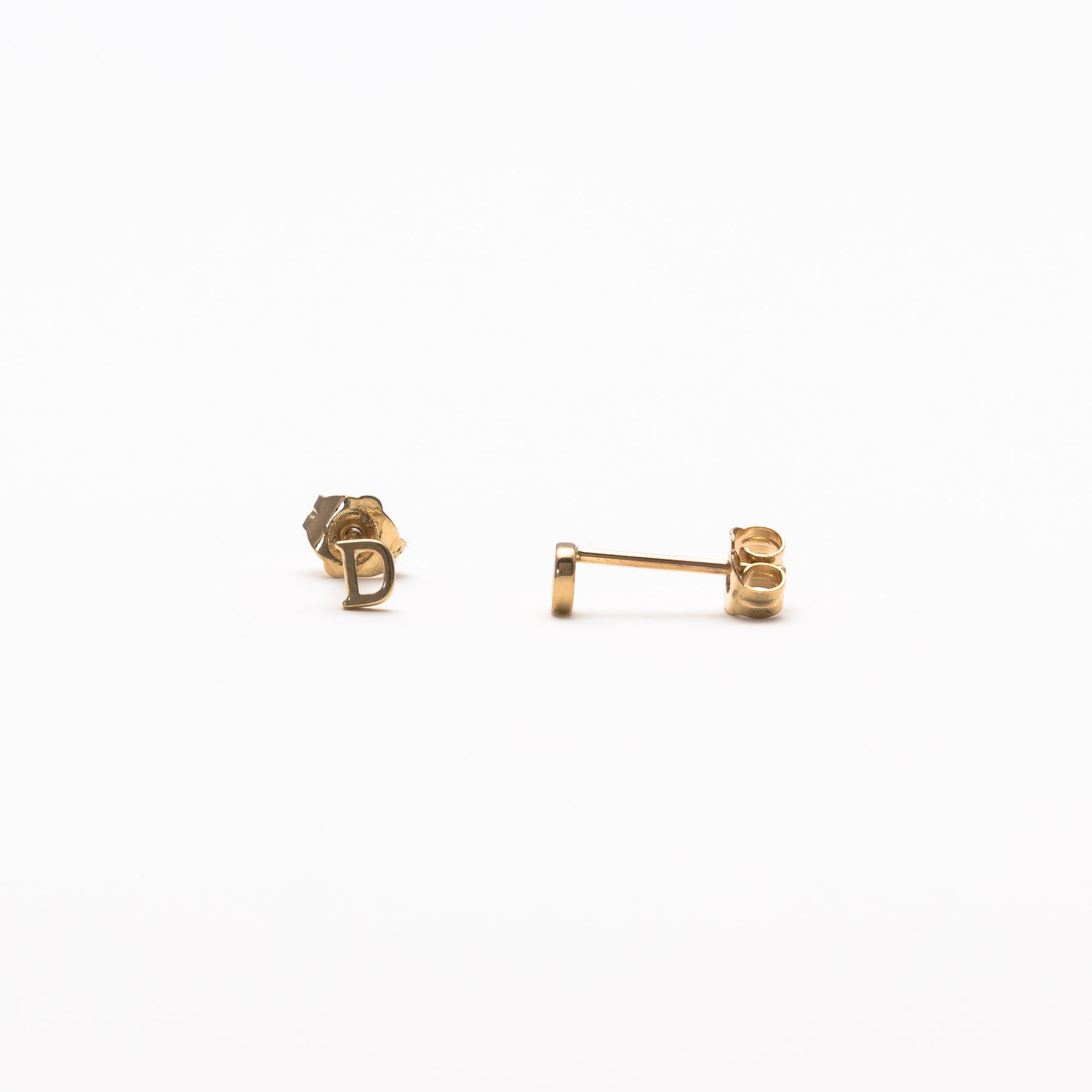 Single initial studs in yellow gold