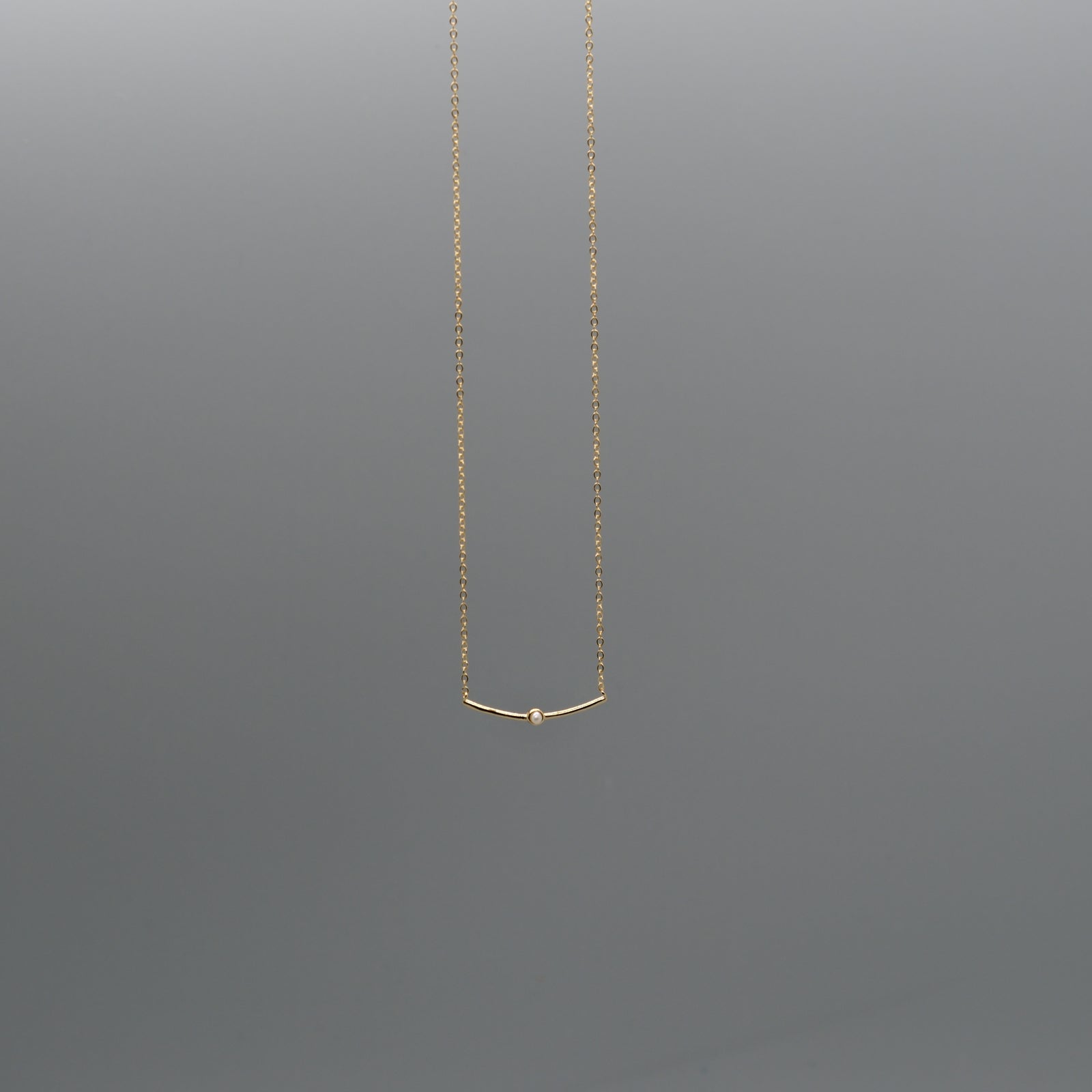 Curved bar with pearl necklace