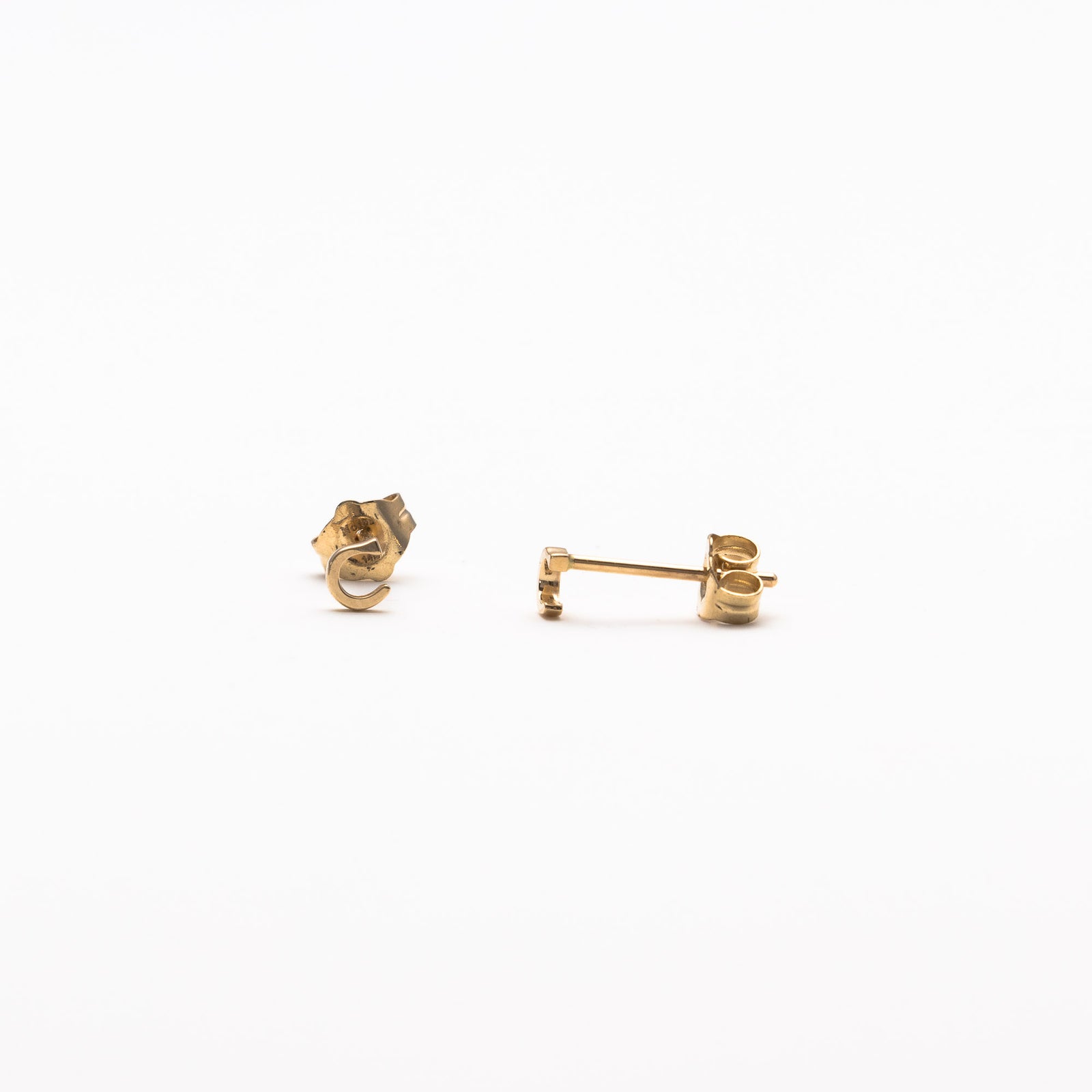 Single initial studs in yellow gold