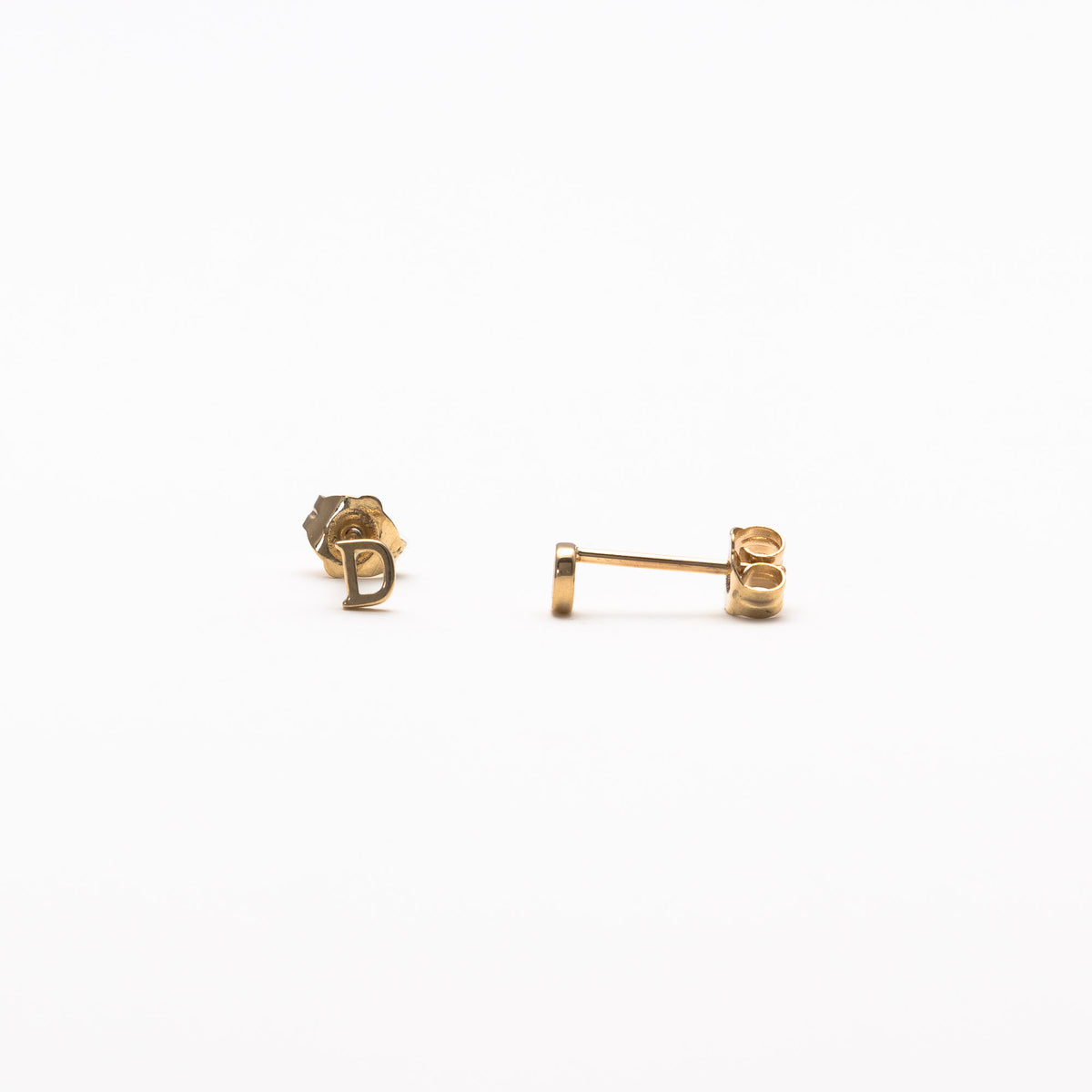 Single initial studs in yellow gold