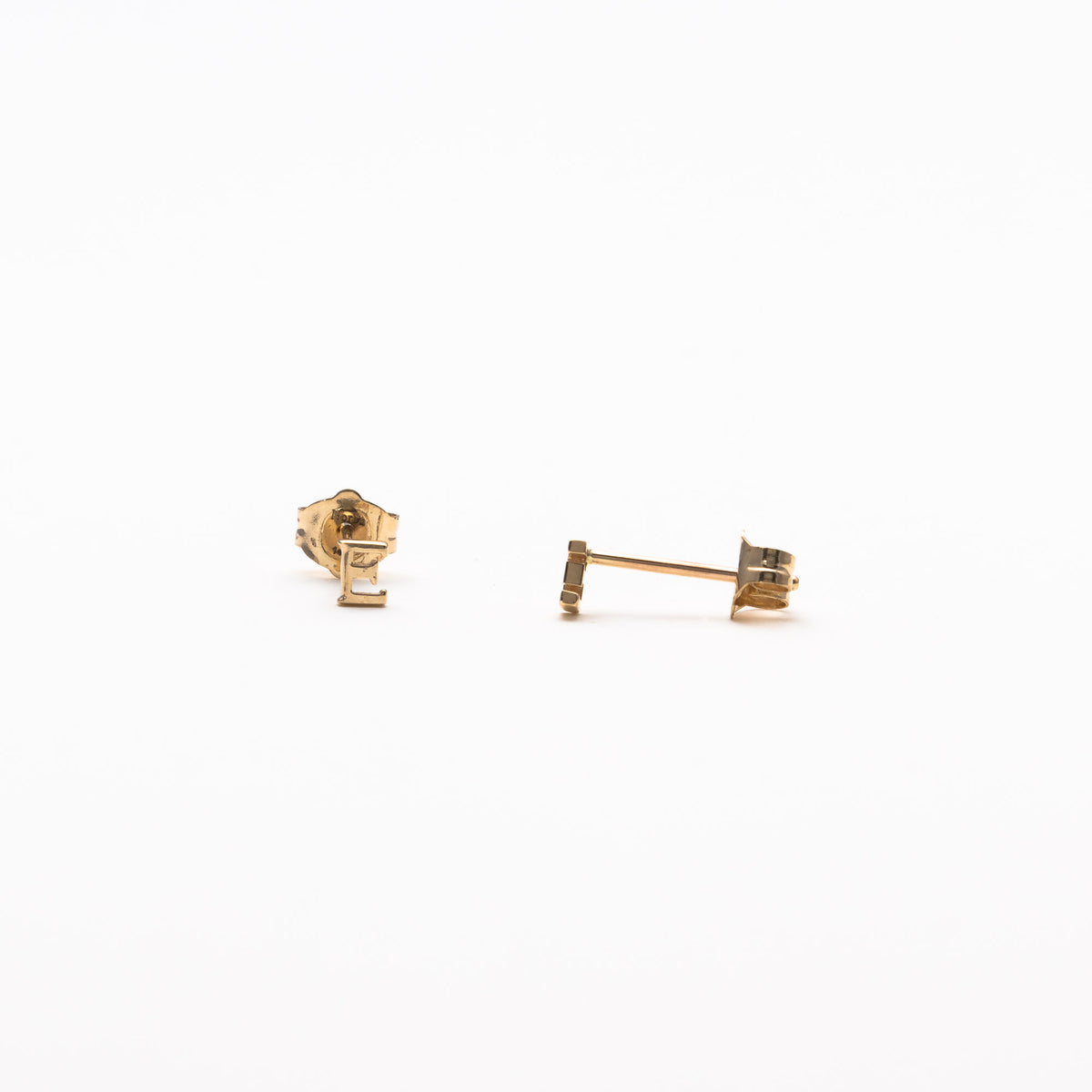 Single initial studs in yellow gold