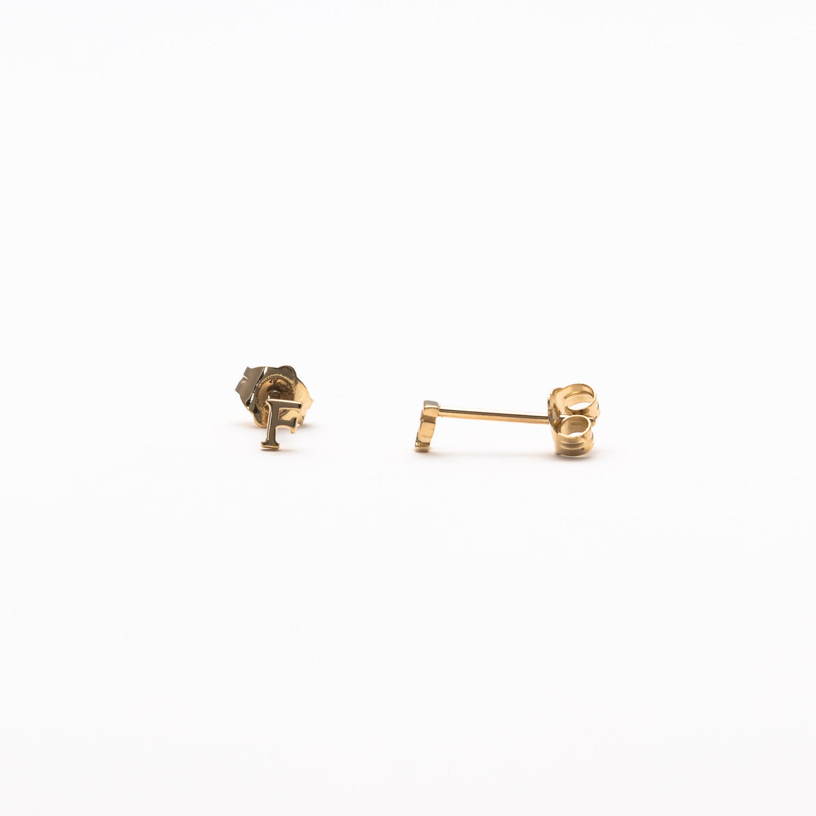 Single initial studs in yellow gold