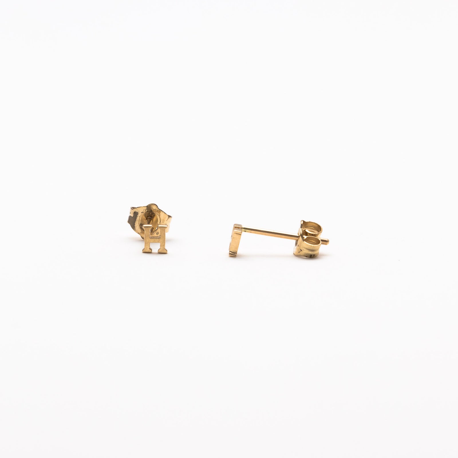 Single initial studs in yellow gold
