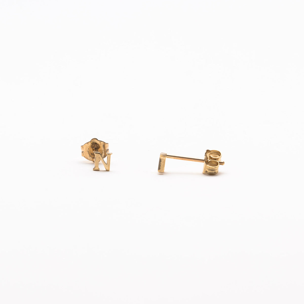 Single initial studs in yellow gold