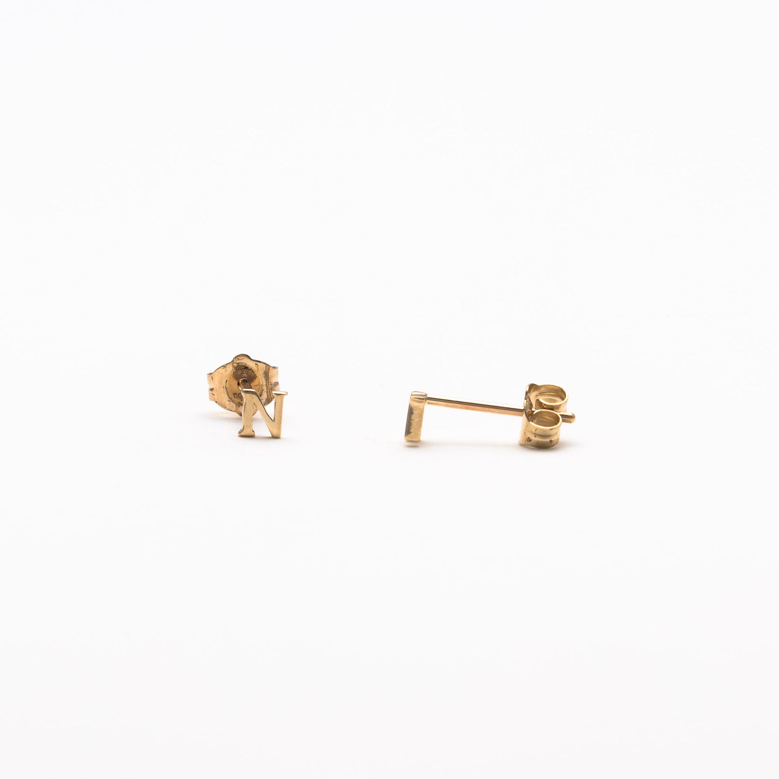 Single initial studs in yellow gold