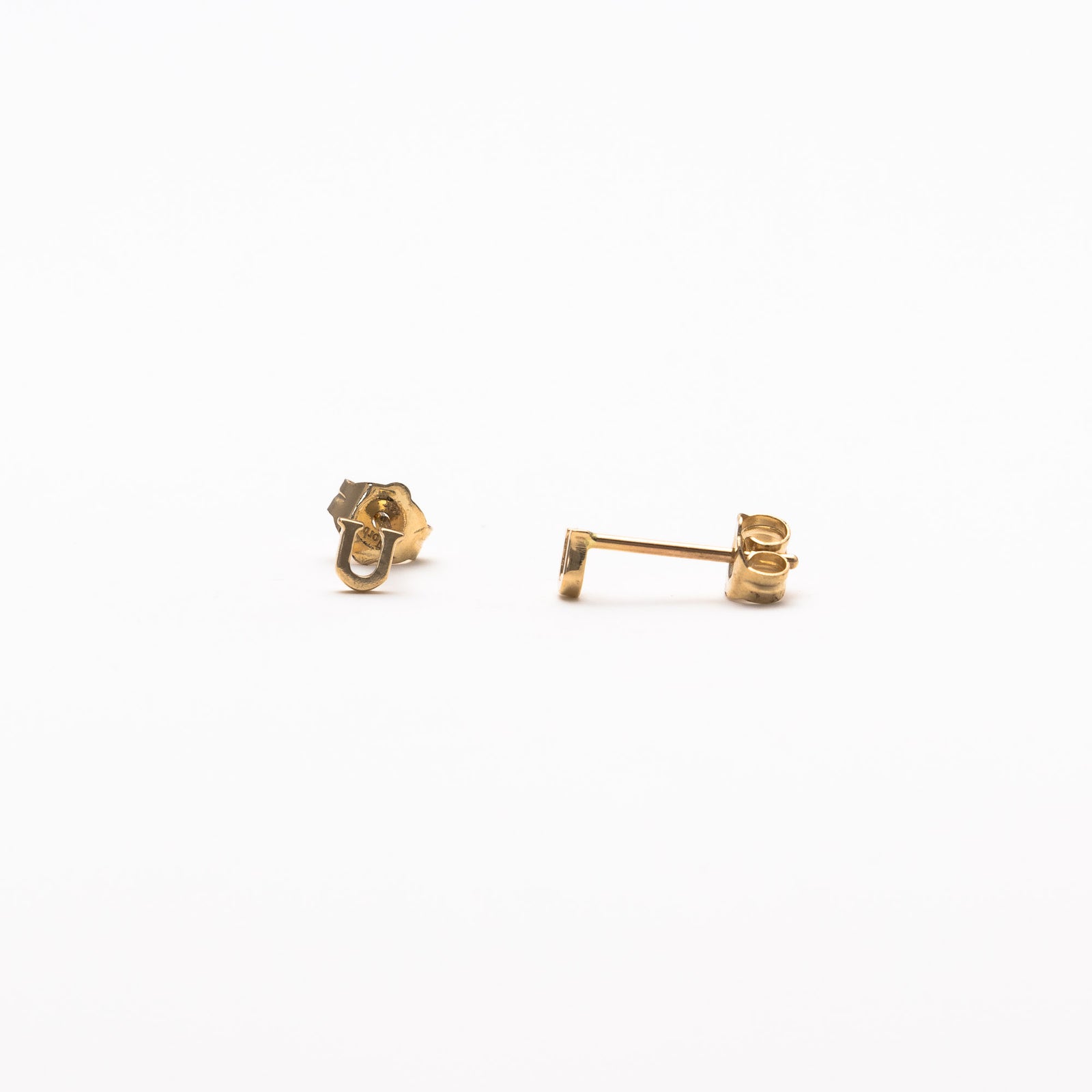 Single initial studs in yellow gold